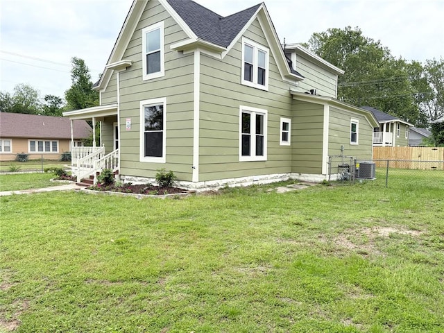back of property with central AC, covered porch, and roof with shingles