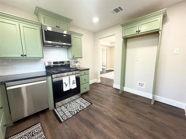 kitchen featuring green cabinets, stainless steel appliances, dark countertops, baseboards, and dark wood-type flooring