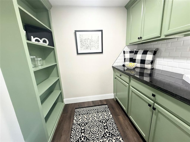 bar with dark wood-type flooring, tasteful backsplash, and baseboards