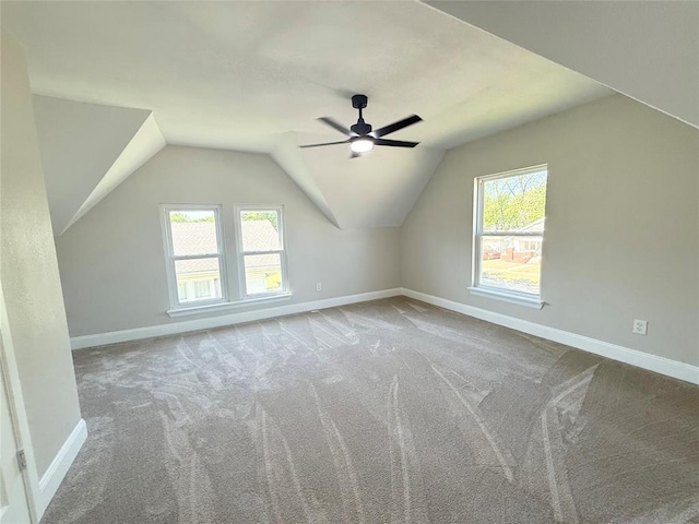 additional living space with carpet floors, baseboards, lofted ceiling, and ceiling fan
