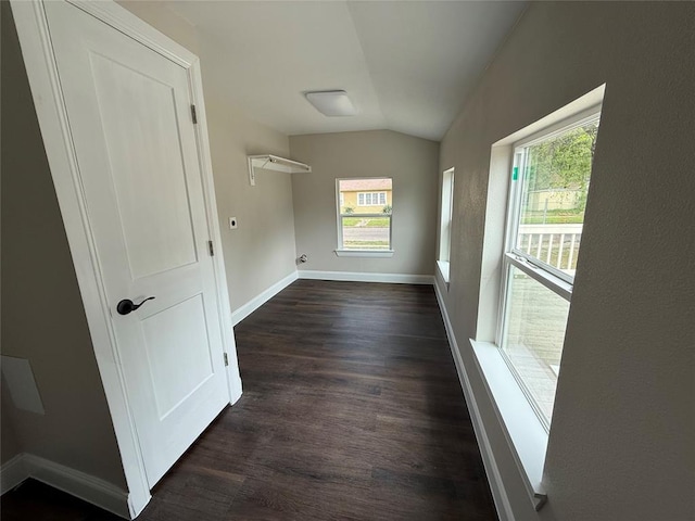 unfurnished room with vaulted ceiling, dark wood finished floors, and baseboards