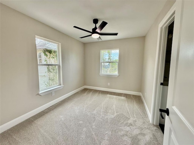 spare room featuring carpet floors, baseboards, and a ceiling fan