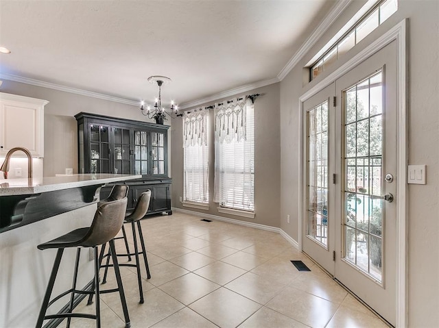3133 Beacon Hill St, Edmond, OK 73034 - dining room with a chandelier, light tile patterned floors, healthy amount of natural light, and crown molding