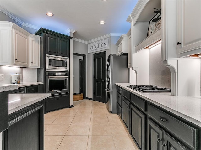 3133 Beacon Hill St, Edmond, OK 73034 - kitchen with appliances with stainless steel finishes, white cabinets, light tile patterned floors, dark cabinetry, and ornamental molding