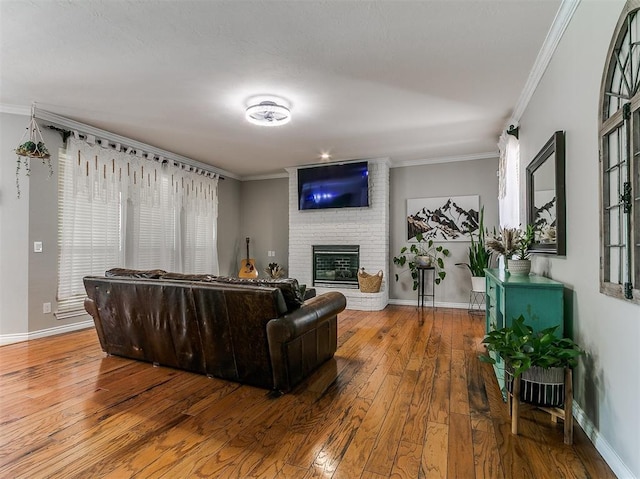 3133 Beacon Hill St, Edmond, OK 73034 - living room with wood-type flooring, a brick fireplace, and ornamental molding