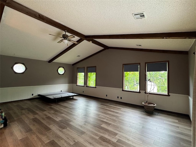 804 William Blvd, Seminole, OK 74868 - unfurnished living room featuring a ceiling fan, a textured ceiling, a wainscoted wall, and wood finished floors