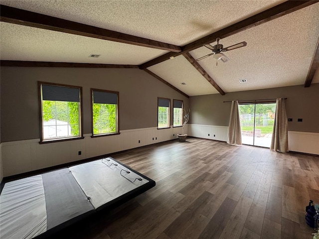 804 William Blvd, Seminole, OK 74868 - interior space featuring a textured ceiling, a ceiling fan, a wainscoted wall, and wood finished floors