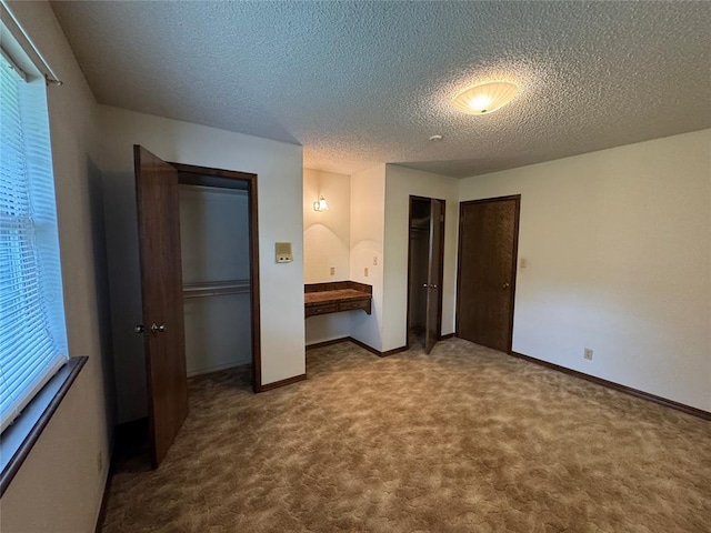 804 William Blvd, Seminole, OK 74868 - unfurnished bedroom featuring carpet, two closets, baseboards, and a textured ceiling