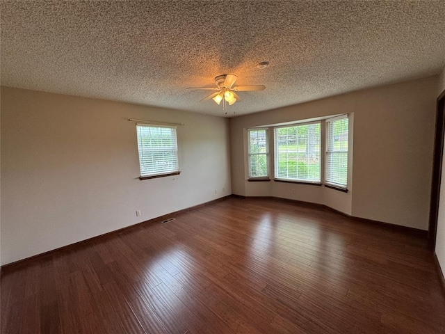 804 William Blvd, Seminole, OK 74868 - unfurnished room featuring a healthy amount of sunlight, ceiling fan, a textured ceiling, and wood finished floors