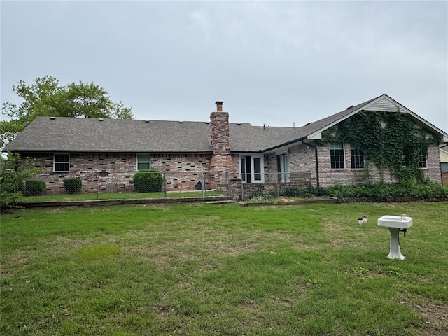 804 William Blvd, Seminole, OK 74868 - back of house with roof with shingles, fence, brick siding, a chimney, and a lawn