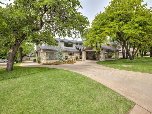 1011 Saint Andrews Dr, Edmond, OK 73025 - view of front of home with stone siding, a front yard, and concrete driveway