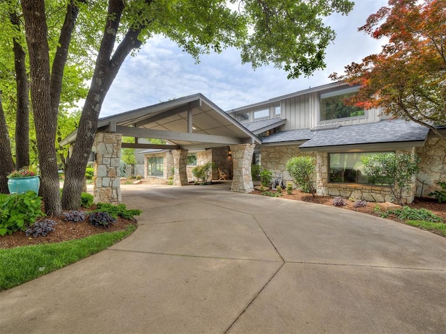 1011 Saint Andrews Dr, Edmond, OK 73025 - view of front of home featuring stone siding, concrete driveway, and board and batten siding
