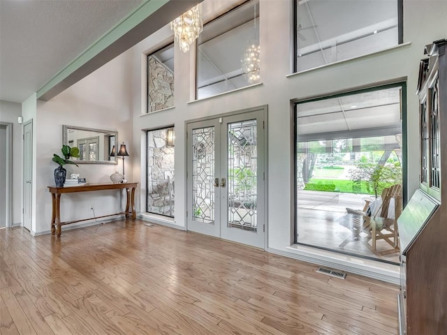 1011 Saint Andrews Dr, Edmond, OK 73025 - entrance foyer with french doors, wood finished floors, a towering ceiling, and a chandelier