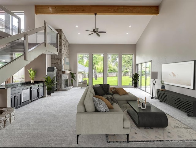 1011 Saint Andrews Dr, Edmond, OK 73025 - carpeted living area with high vaulted ceiling, plenty of natural light, a ceiling fan, beam ceiling, and stairs