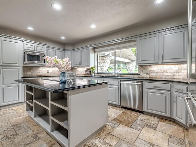 1011 Saint Andrews Dr, Edmond, OK 73025 - kitchen featuring appliances with stainless steel finishes, stone tile floors, recessed lighting, dark countertops, and open shelves