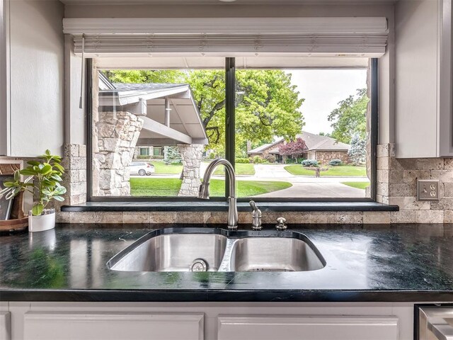 1011 Saint Andrews Dr, Edmond, OK 73025 - kitchen view of backsplash, dark countertops, and white cabinets