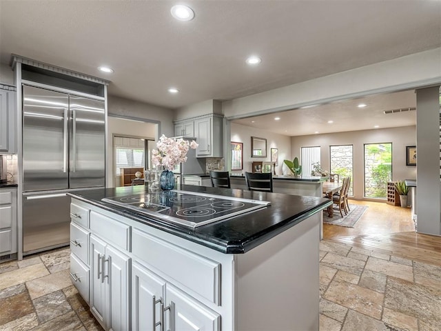 1011 Saint Andrews Dr, Edmond, OK 73025 - kitchen with built in refrigerator, stone tile floors, electric stovetop, dark countertops, and recessed lighting