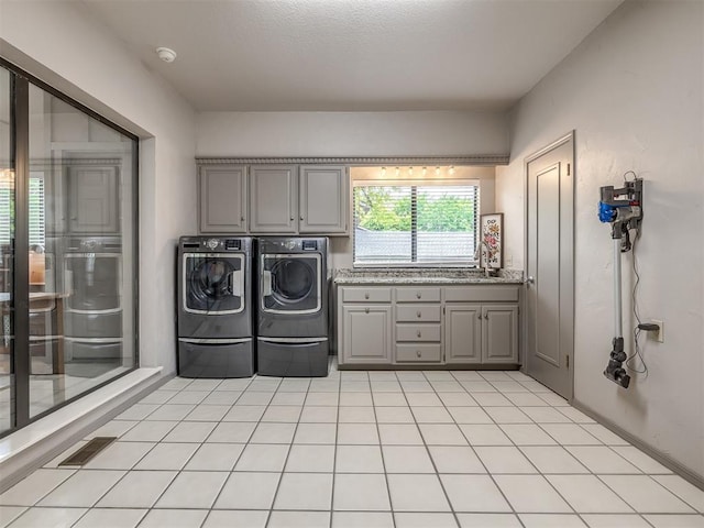 1011 Saint Andrews Dr, Edmond, OK 73025 - laundry room with cabinet space, washer and dryer, and light tile patterned flooring