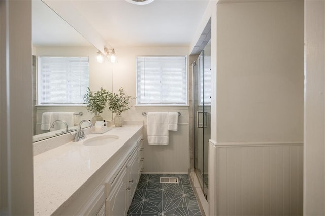 3205 NW 54th Cir, Oklahoma City, OK 73112 - bathroom featuring vanity, a shower stall, a wainscoted wall, and tile patterned floors