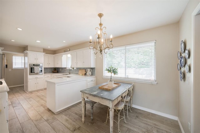 3205 NW 54th Cir, Oklahoma City, OK 73112 - kitchen featuring appliances with stainless steel finishes, light wood-style floors, white cabinets, recessed lighting, and tasteful backsplash