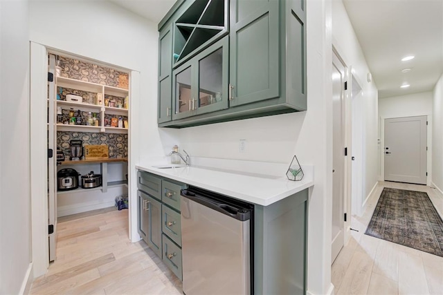 bar area featuring light wood-type flooring, refrigerator, a sink, and recessed lighting