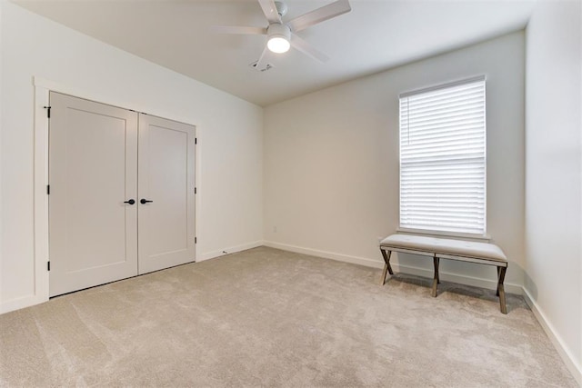 unfurnished bedroom with light carpet, baseboards, and ceiling fan