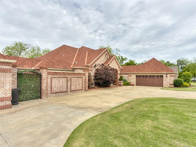 9408 S Caldwell Dr, Midwest City, OK 73130 - view of front of home featuring brick siding, concrete driveway, a front yard, and an attached garage