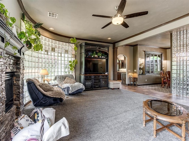 9408 S Caldwell Dr, Midwest City, OK 73130 - living area with ornamental molding, a ceiling fan, a fireplace, arched walkways, and carpet flooring