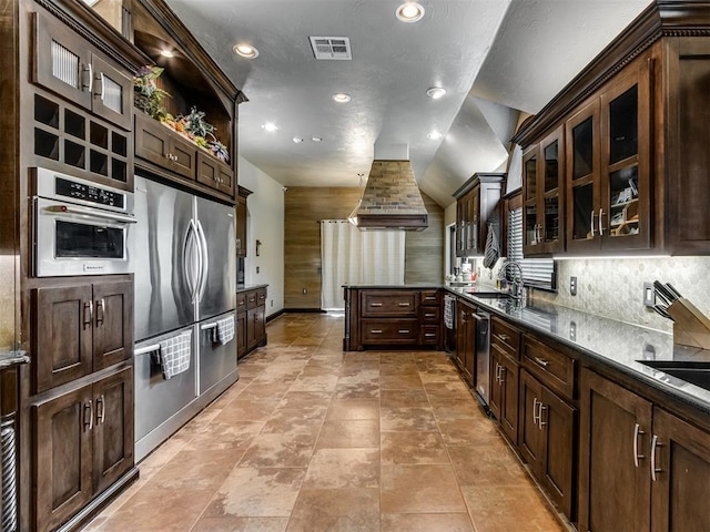 9408 S Caldwell Dr, Midwest City, OK 73130 - kitchen with stainless steel appliances, a peninsula, recessed lighting, dark brown cabinetry, and glass insert cabinets