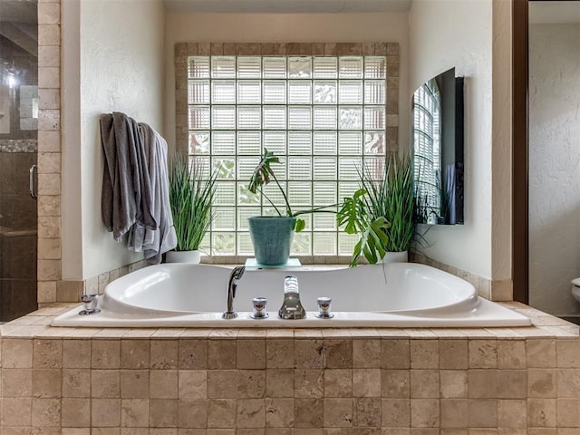 9408 S Caldwell Dr, Midwest City, OK 73130 - bathroom with a textured wall and a garden tub