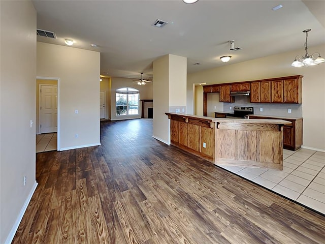 kitchen with light wood-type flooring, open floor plan, visible vents, and stainless steel electric stove