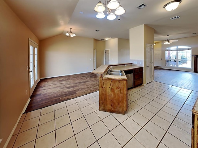 kitchen featuring a peninsula, light tile patterned floors, visible vents, and open floor plan