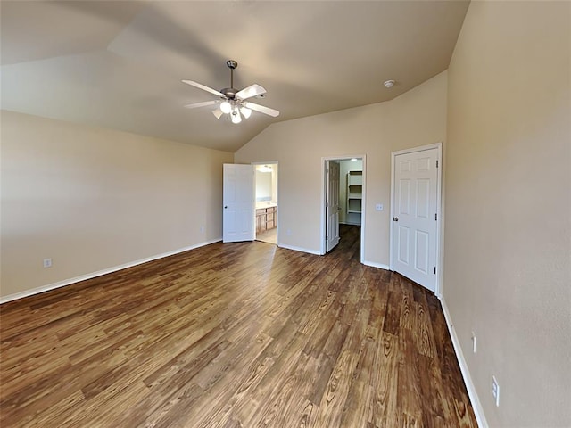 unfurnished bedroom featuring baseboards, wood finished floors, and vaulted ceiling