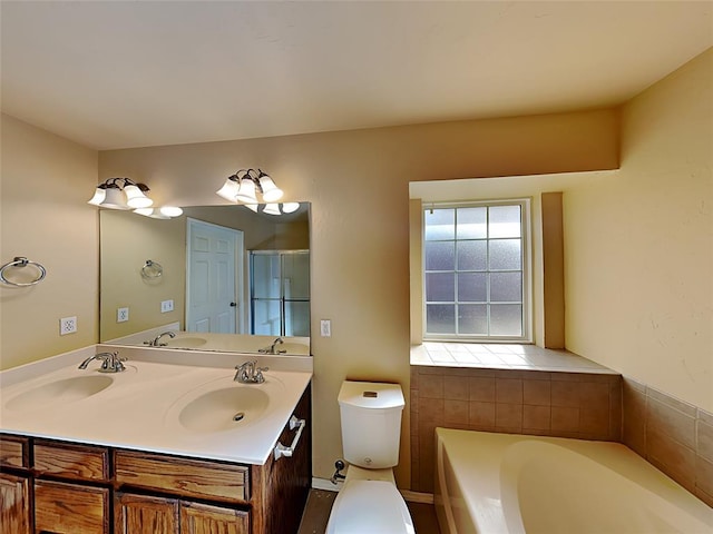 full bathroom with toilet, a bath, double vanity, and a sink