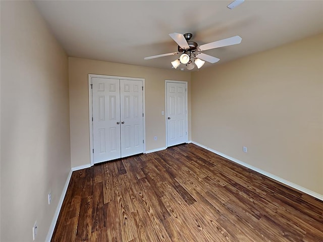 unfurnished bedroom with a ceiling fan, baseboards, dark wood-style floors, and a closet