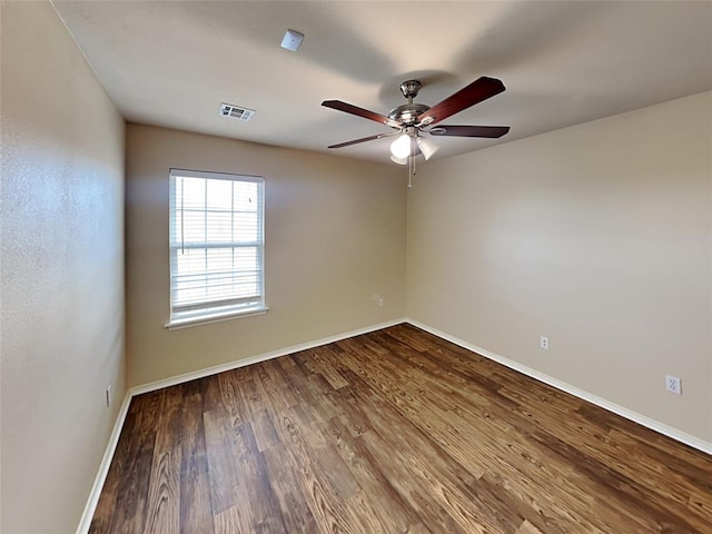 unfurnished room with a ceiling fan, baseboards, visible vents, and wood finished floors
