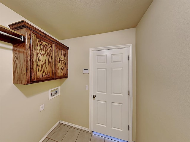 washroom featuring cabinet space, light tile patterned floors, baseboards, and hookup for a washing machine