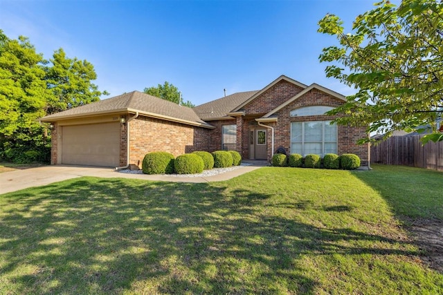 single story home featuring an attached garage, fence, a front lawn, concrete driveway, and brick siding