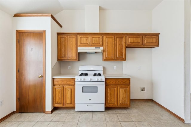 kitchen featuring under cabinet range hood, white gas range oven, light countertops, and brown cabinets