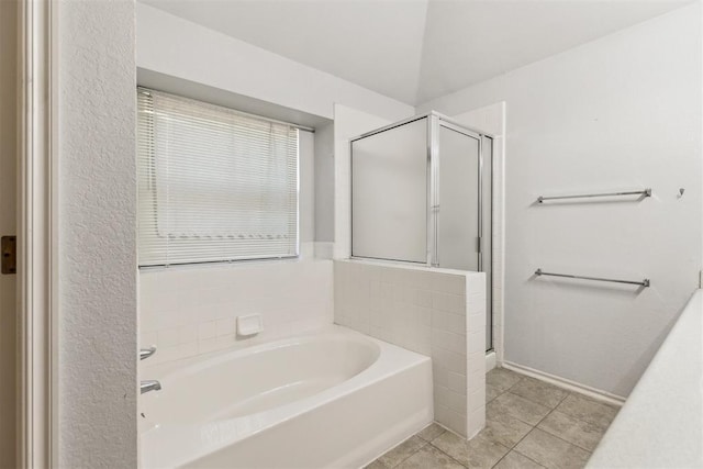 bathroom with a shower stall, a bath, and tile patterned floors