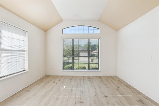 unfurnished room with vaulted ceiling, baseboards, and wood finished floors