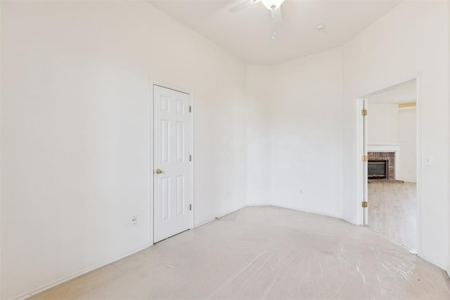 empty room with a ceiling fan and a fireplace