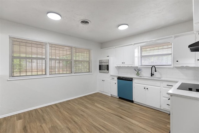 3601 N Terry Ave, Oklahoma City, OK 73111 - kitchen featuring a sink, oven, dishwashing machine, black electric cooktop, and light wood-style floors