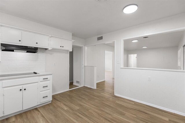 3601 N Terry Ave, Oklahoma City, OK 73111 - kitchen with black electric cooktop, light wood-type flooring, visible vents, backsplash, and under cabinet range hood