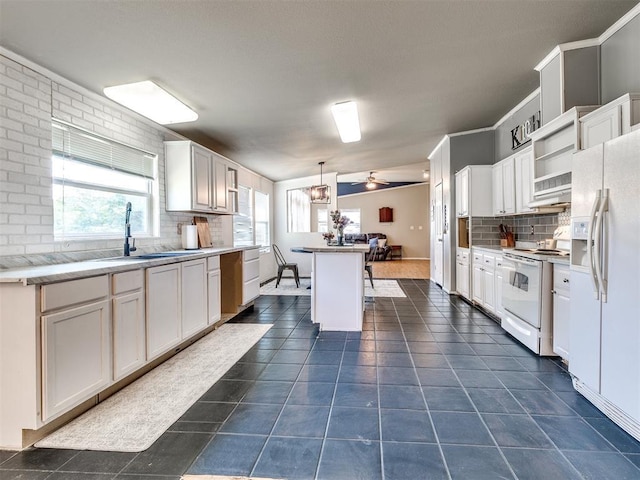 kitchen featuring a sink, white appliances, white cabinetry, and backsplash