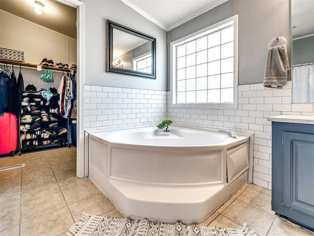 bathroom featuring a walk in closet, tile patterned floors, tile walls, vanity, and ornamental molding