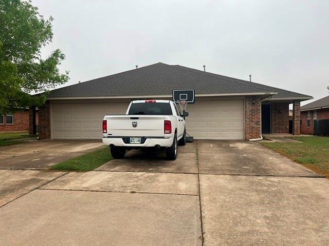 1604 W Palm Pl, Oklahoma City, OK 73128 - view of front of house featuring driveway, an attached garage, and brick siding