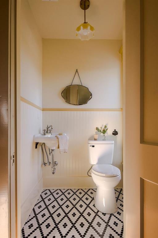 1801 N Broadway Ave, Shawnee, OK 74804 - half bathroom with tile patterned flooring, toilet, and a wainscoted wall