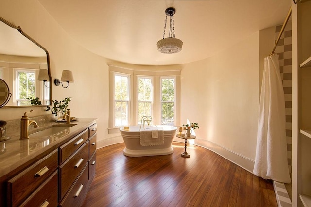 1801 N Broadway Ave, Shawnee, OK 74804 - bathroom featuring vanity, hardwood / wood-style floors, a freestanding bath, and baseboards