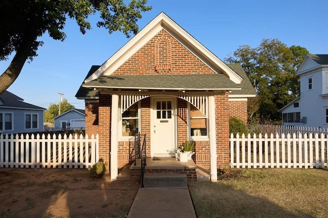 1801 N Broadway Ave, Shawnee, OK 74804 - view of front of house with brick siding, a shingled roof, and fence